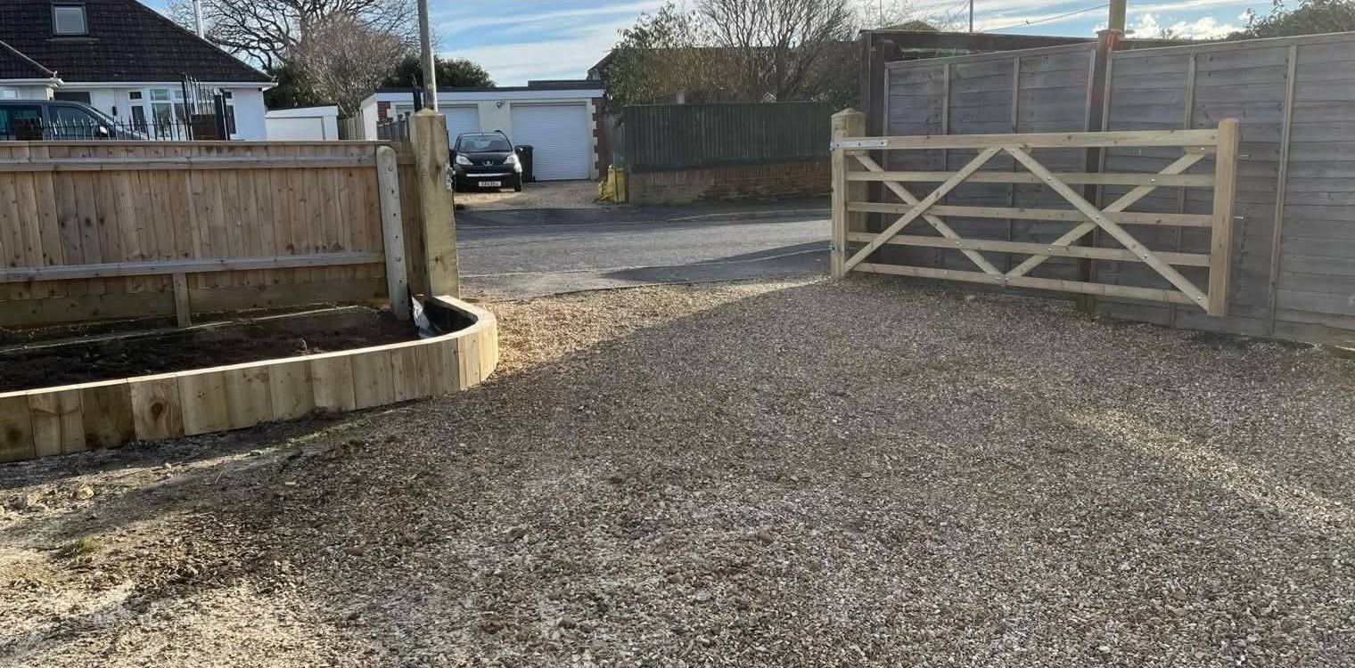 After: shingle driveway with a new timber five-bar gate and curved sleeper border